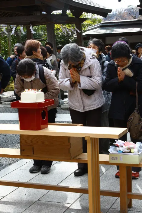 Mujeres orando frente al bloque de tofu donde enterraron sus agujas durante el Hari Kuyo.