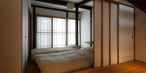 La séparation entre la chambre et la pièce de vie se fait grâce à des fusuma, portes coulissantes en bois (opaques) à droite.