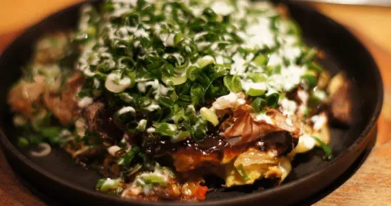 Un okonomiyaki tout juste servi.